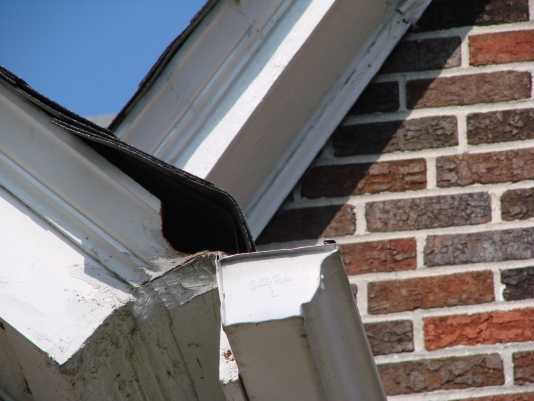 Damaged Gutter with Brick Wall